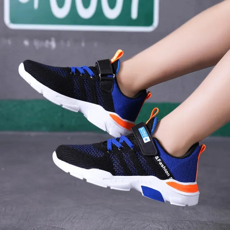 Black and blue athletic shoes with orange accents worn by a person, against a blurred background.