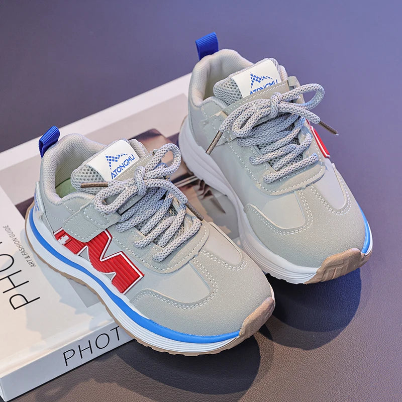 Gray sneakers with red and blue accents on a purple surface