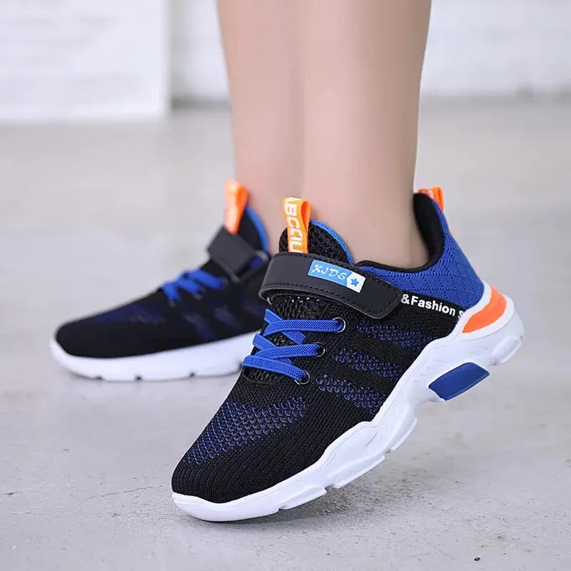 Black and blue sneakers with orange accents on a light gray floor.