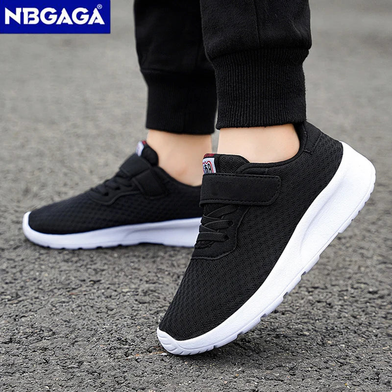 Black sneakers with white soles worn by a person on a gray pavement, with NBGAGA branding.